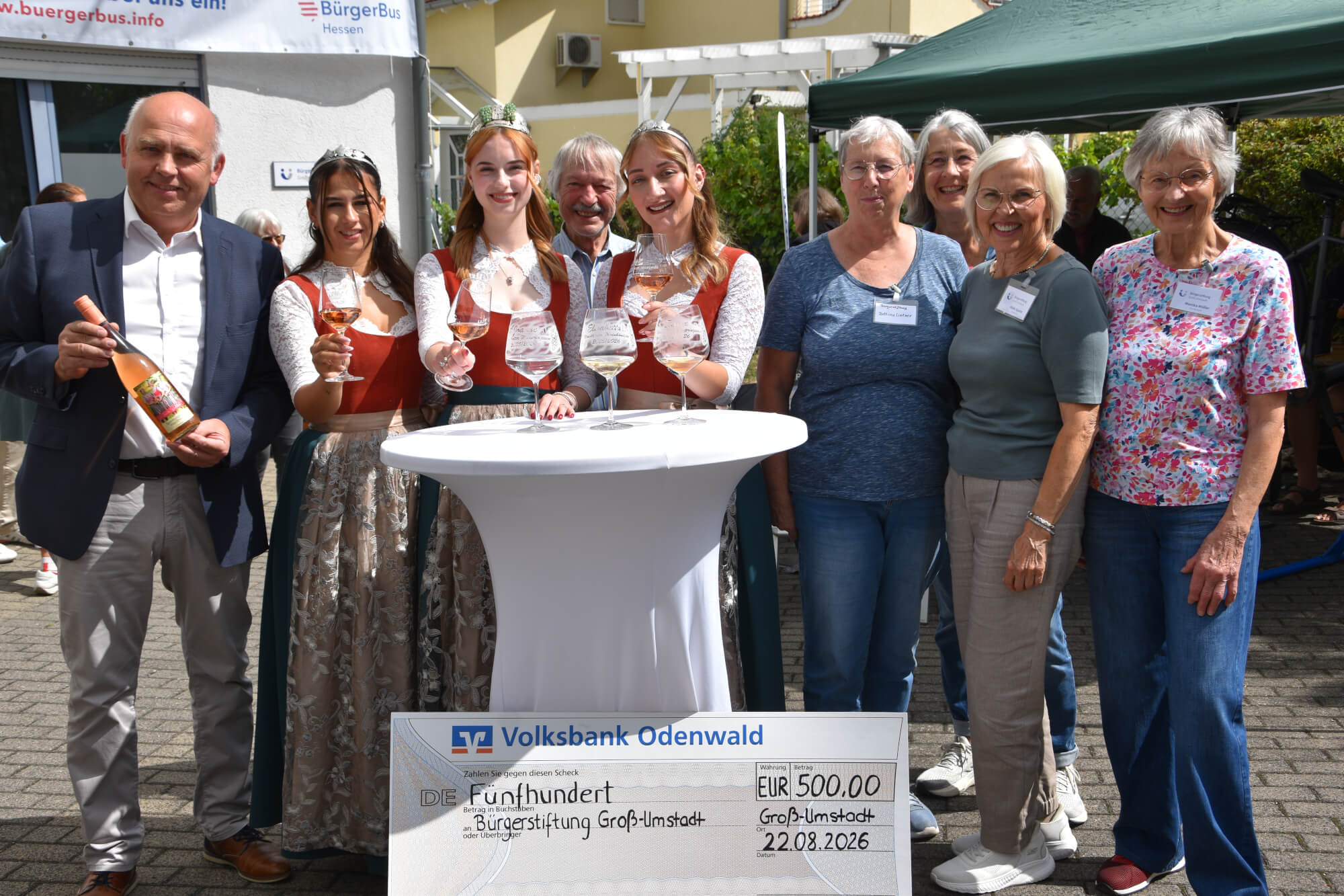 Gruppenbild der Weinhoheiten mit Mitgliedern aus Bürgerstiftung, Kunterbunt und Winzergenossenschaft bei der Spendenübergabe an die Bürgerstiftung